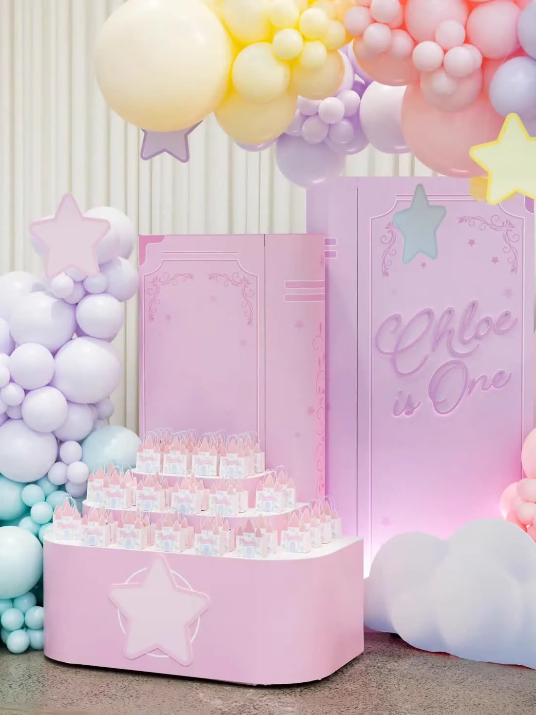 Pink first birthday backdrop panels with balloon styling