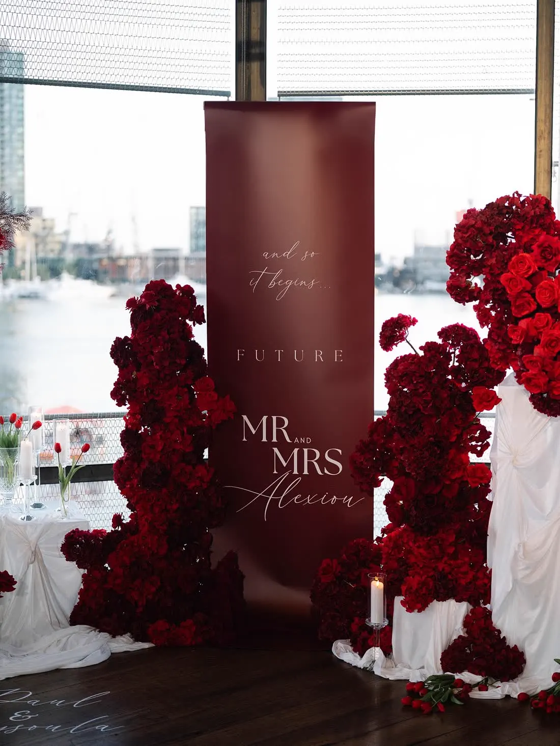 Burgundy wedding welcome sign with red floral styling
