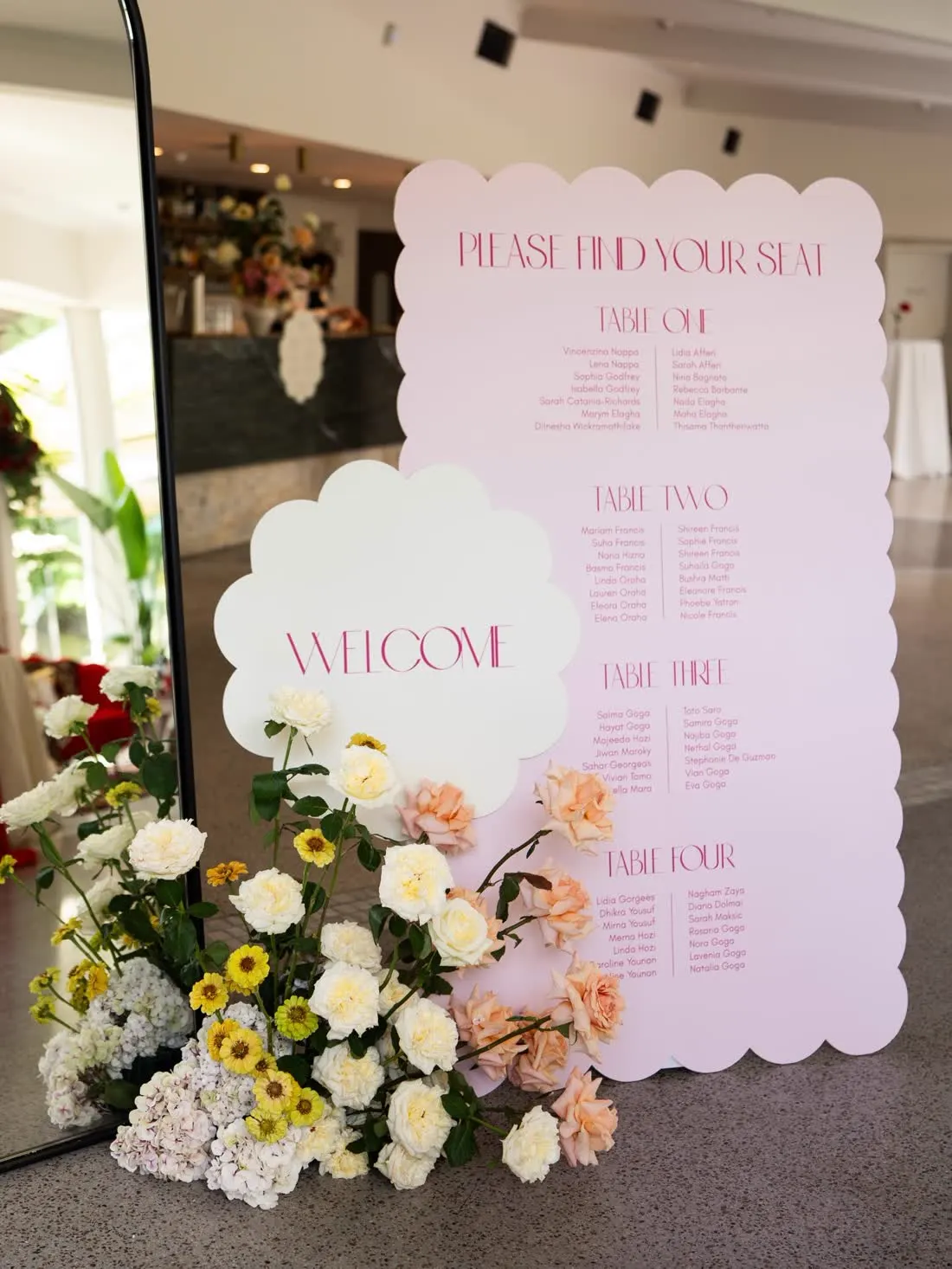 Scalloped acrylic welcome sign and seating chart with florals